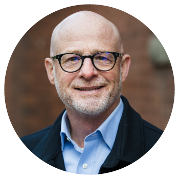 Smiling bald man wearing glasses and a blue shirt
