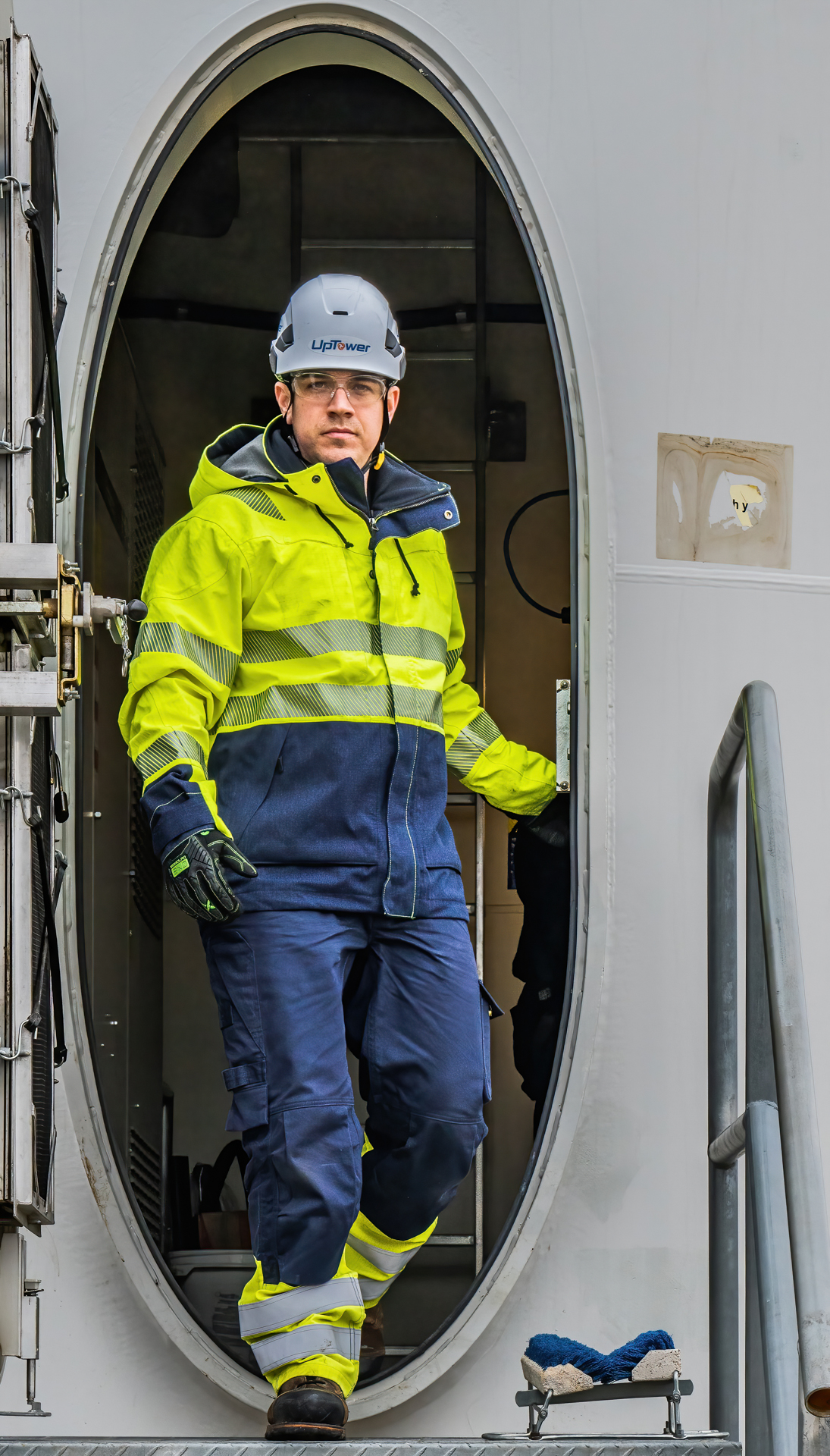 Worker in safety gear exits an aircraft hatch